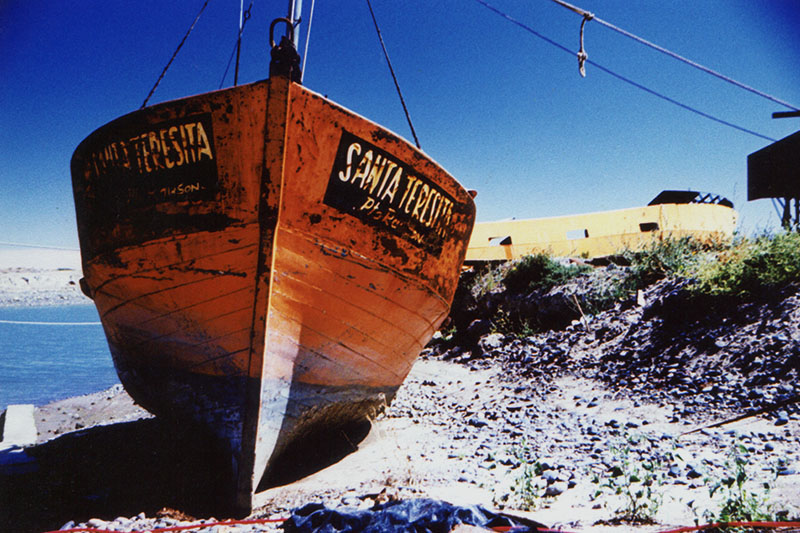 The fishing boat Santa Teresita sits on dry land at a boatyard outside Puerto Madryn, Argentina. Cross Process.