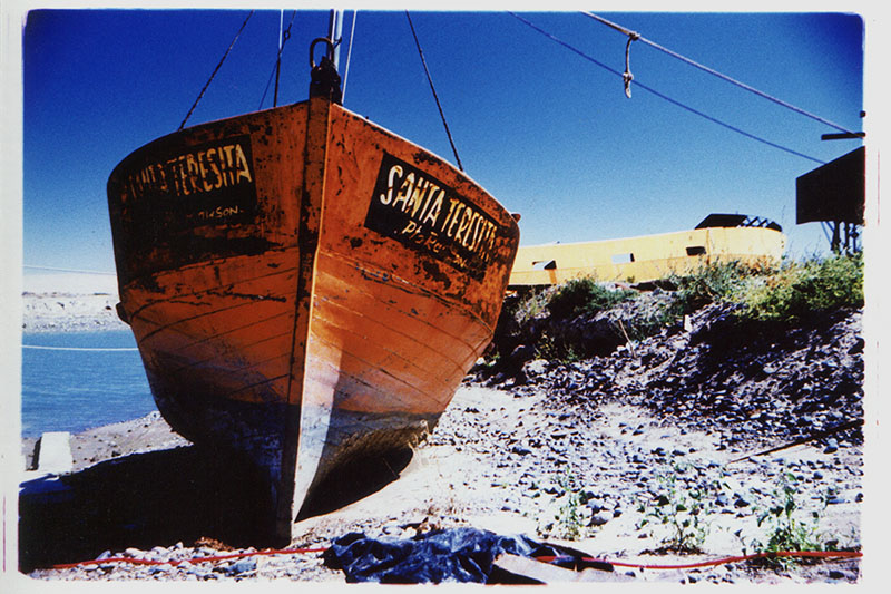 The fishing boat Santa Teresita sits on dry land at a boatyard outside Puerto Madryn, Argentina. Cross Process.
