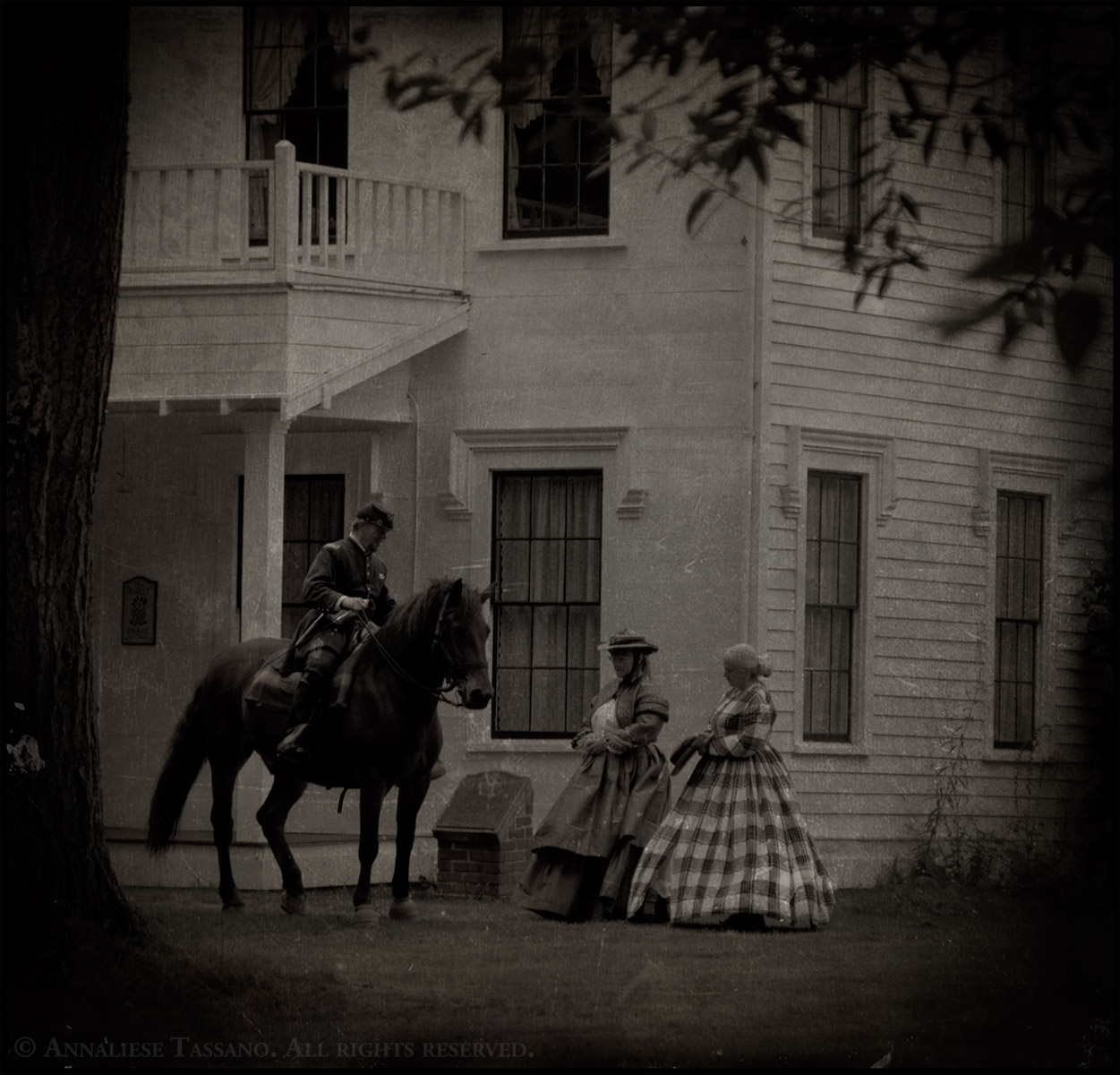 Civil War reenactors in Washington State, one man mounted on his Canadian Warmblood horse in his Union Cavalry uniform and two women standing on the ground in period dresses.