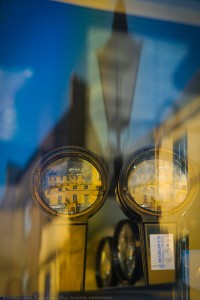 Reflections of blue skies and stone buildings, and magnifying lenses in the window of a Dublin, Ireland optical shop.