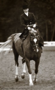 A sepia photo with a vintage feel of a woman riding side saddle.