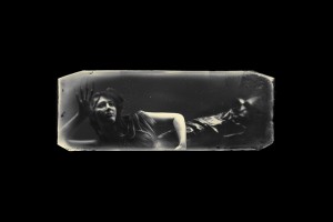 A young mermaid trapped in a tank claws at the glass in a bid to escape.